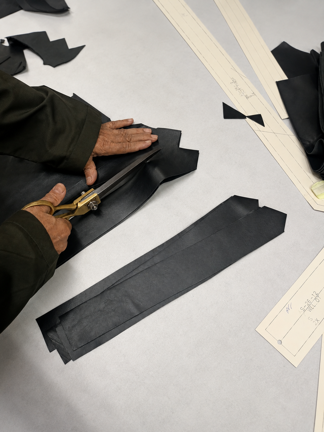 Tailor cutting black leather pattern pieces